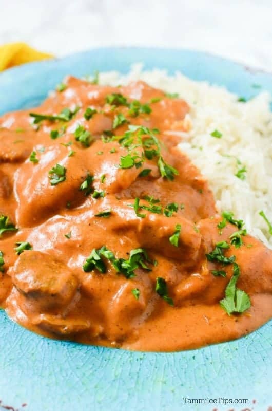  blue plate with chicken tikka masala, white rice, and a fork