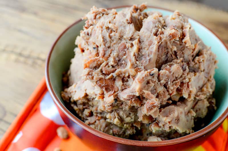 refried beans in a red bowl on a cloth napkin