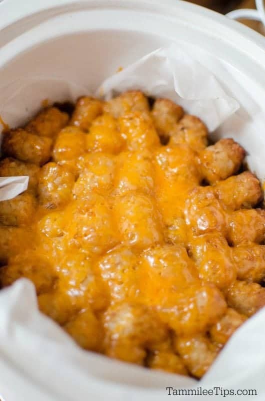 Tater tots covered in cheese in a crockpot