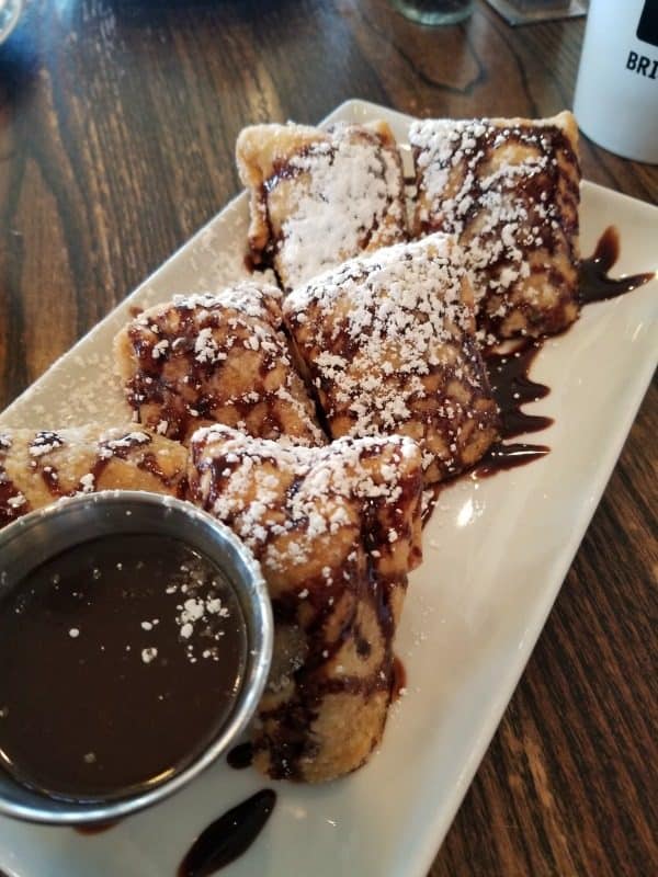 Bananas in Pajamas covered in powdered sugar and chocolate sauce