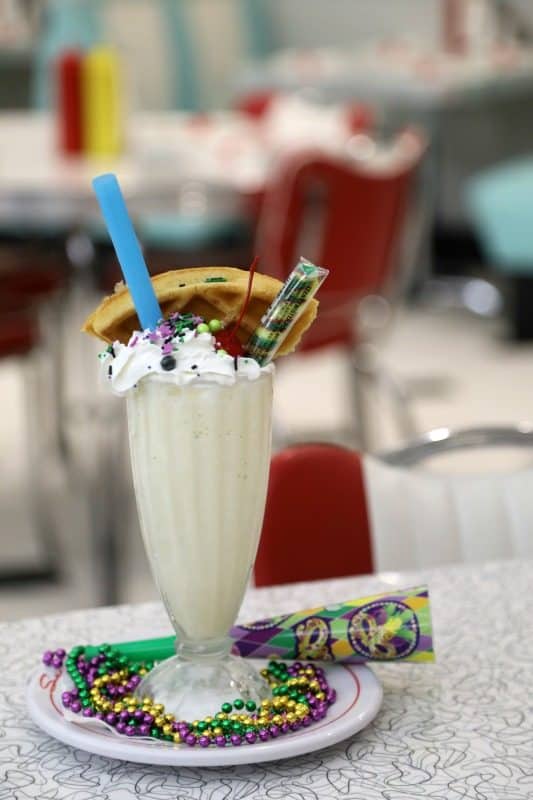 milkshake with Mardi gras beads, and a waffle in it