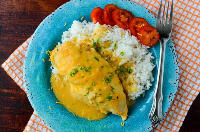 cheesy chicken next to white rice and sliced tomatoes
