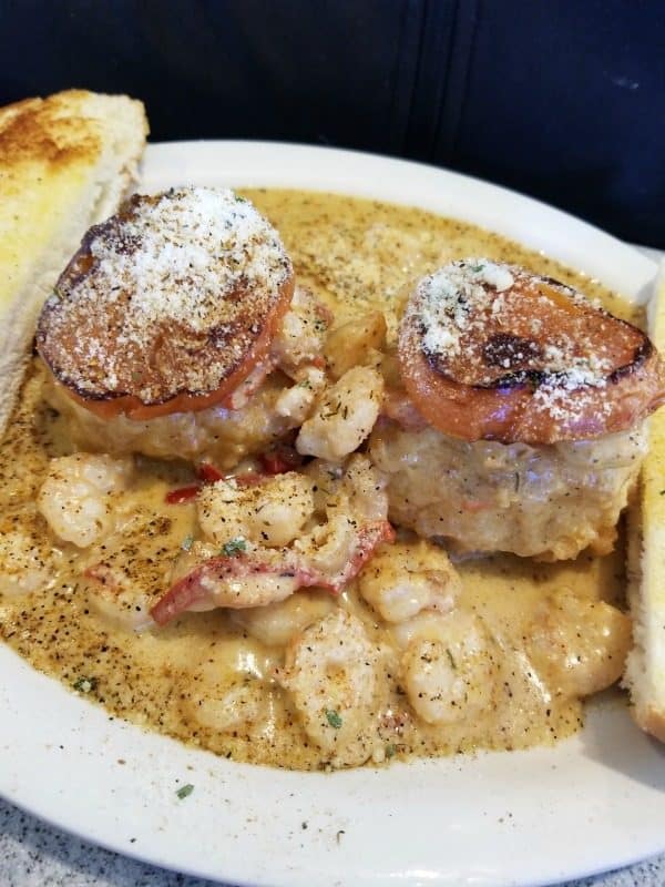 Creole Shrimp and grit cakes on a white plate