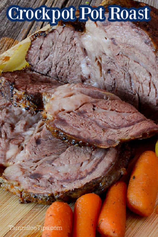 Slices of easy crockpot roast on a wood cutting board next to carrots