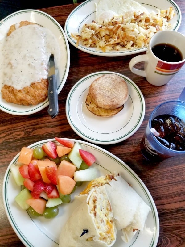 breakfast wrap next to fresh fruit, coffee, and chicken fried steak