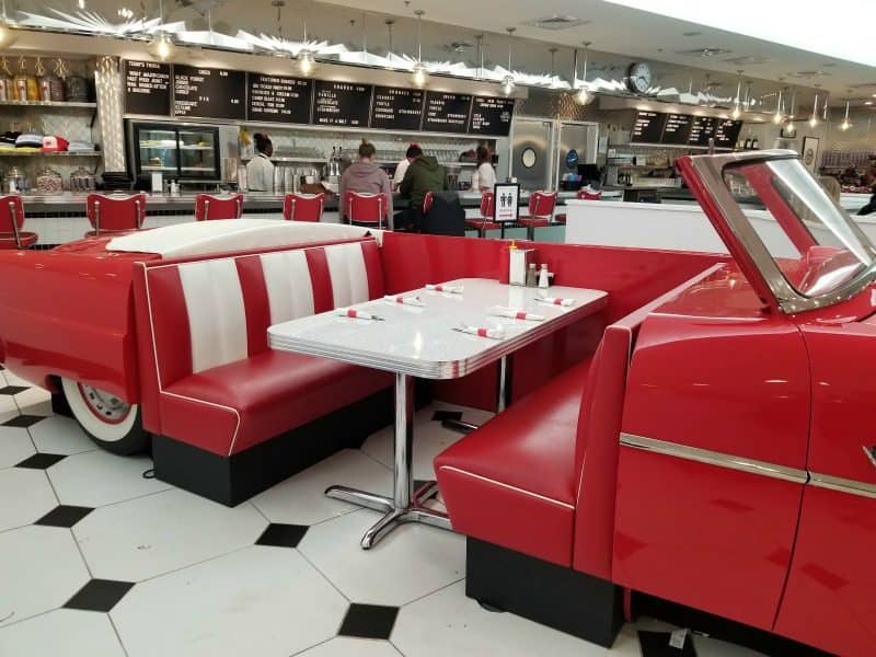 red classic car with table in the middle of it, counter service in the background