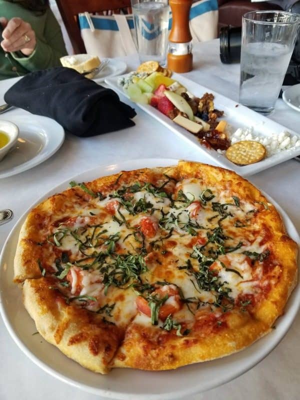 Margherita pizza and charcuterie plate on a white linen table