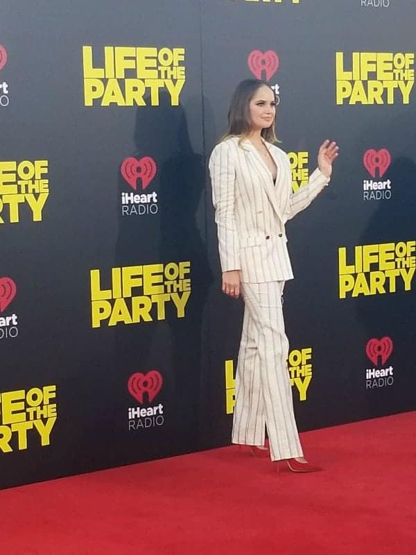 Debby Ryan next to a Life of the Party sign