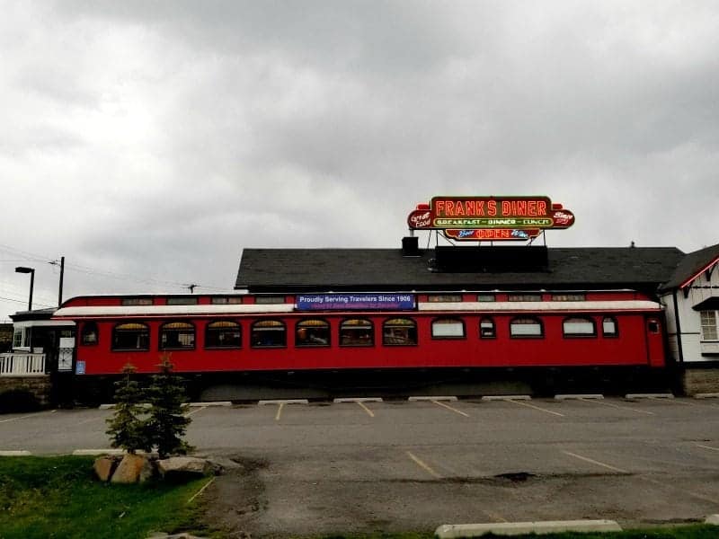 Franks Diner neon sign over a train car and parking lot