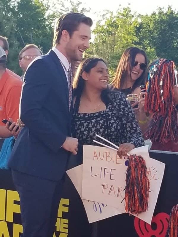 Actor greeting a fan with a Life of the Party sign