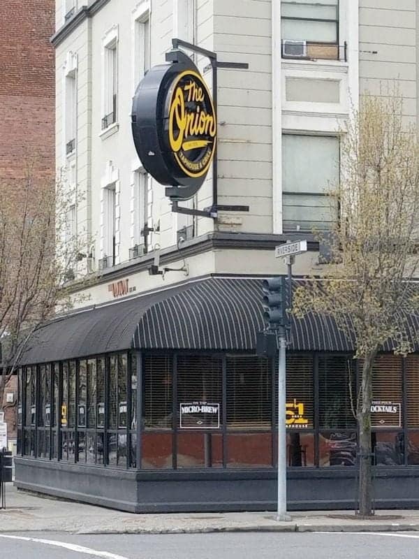 The Onion circle sign over a walkway and building entrance