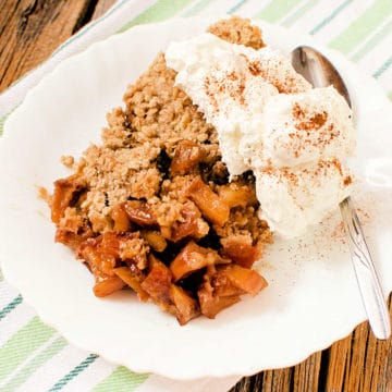 Caramel apple crisp on a white plate with ice cream