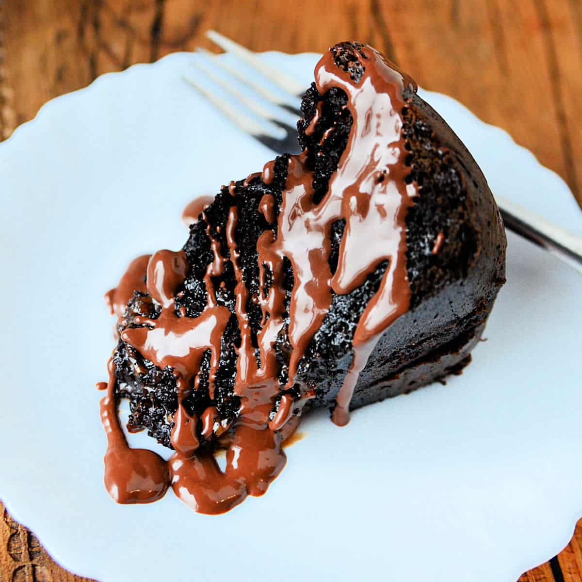 Crock Pot Chocolate Caramel Dump Cake slice on a white plate with a fork