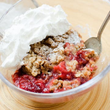 Crock Pot Strawberry Crisp in a glass bowl with a spoon