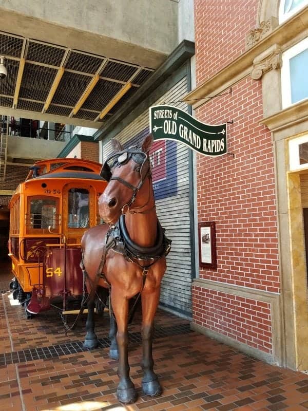 old grand rapids with a horse pulling a trolley car behind it in the museum