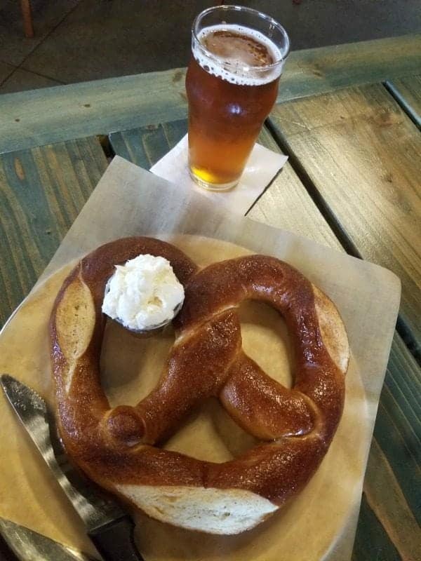 beer glass next to a giant pretzel