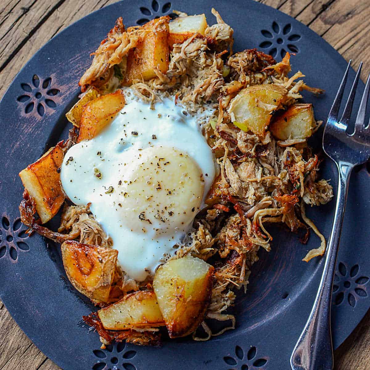 Pulled Pork Breakfast Hash on a blue plate with a fork