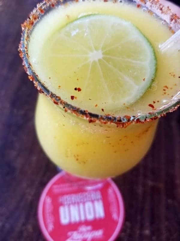 margarita with a spicy rim and lime wheel floating in it