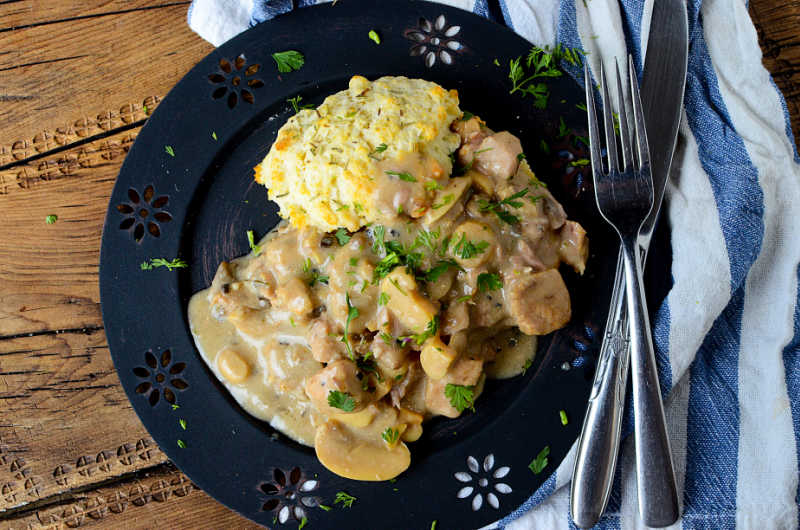 Crockpot Rosemary Pork on a blue plate with a fork and knife