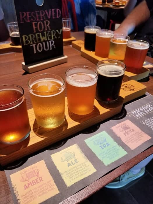 Reserved for brewery tour sign next to wood board with four glasses of bear and a beer menu