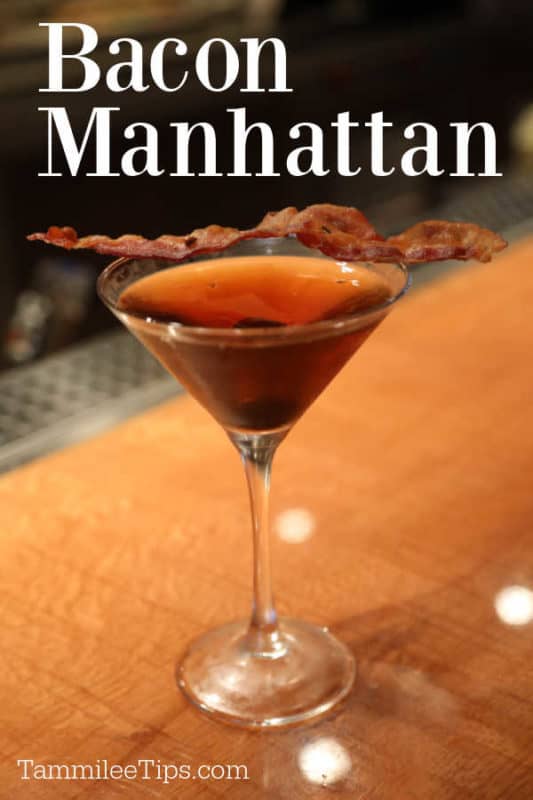 Bacon Manhattan over a martini glass with a strip of bacon on top of it