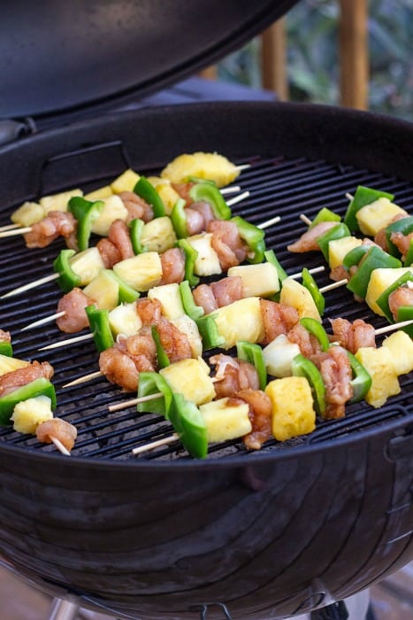 Grilled sweet and spicy chicken skewers on a black barbecue