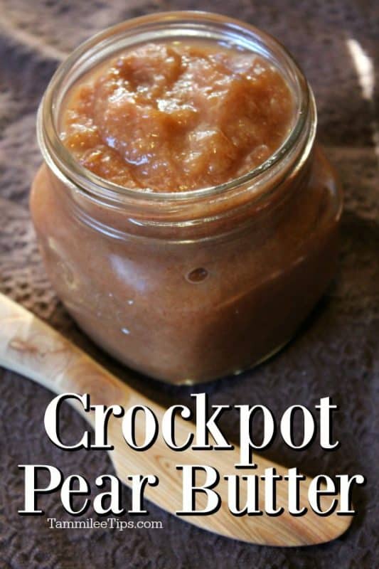 Crockpot pear butter in a glass mason jar on a brown napkin with a wooden knife