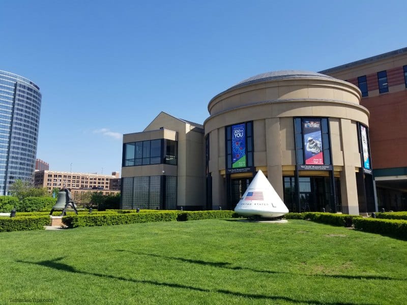 Grand Rapids Museum exterior with green grass lawn, space equipment, and blue skies