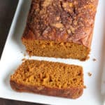 Crockpot Pumpkin Bread with a slice cut on a white platter