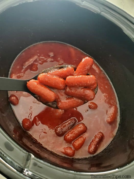 beef little smokies coming out of a slow cooker bowl on a spoon