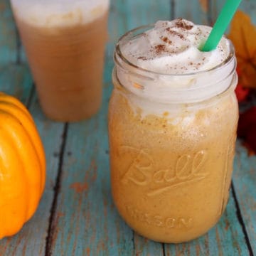 Starbucks Pumpkin Spice Frappuccino in a mason jar next to pumpkins