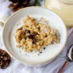 Crock Pot Eggnog Oatmeal in a white bowl next to a spoon