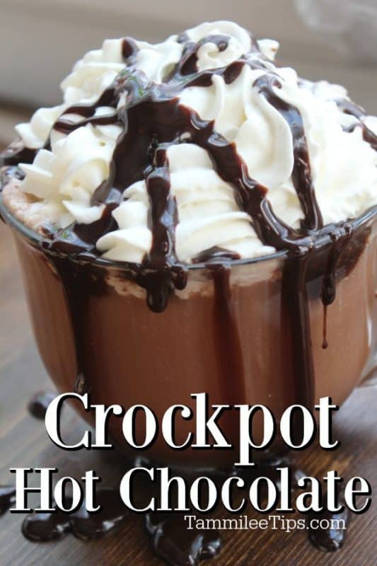 Crockpot hot chocolate text below a glass mug overflowing with slow cooker hot cocoa, chocolate syrup and whipped cream