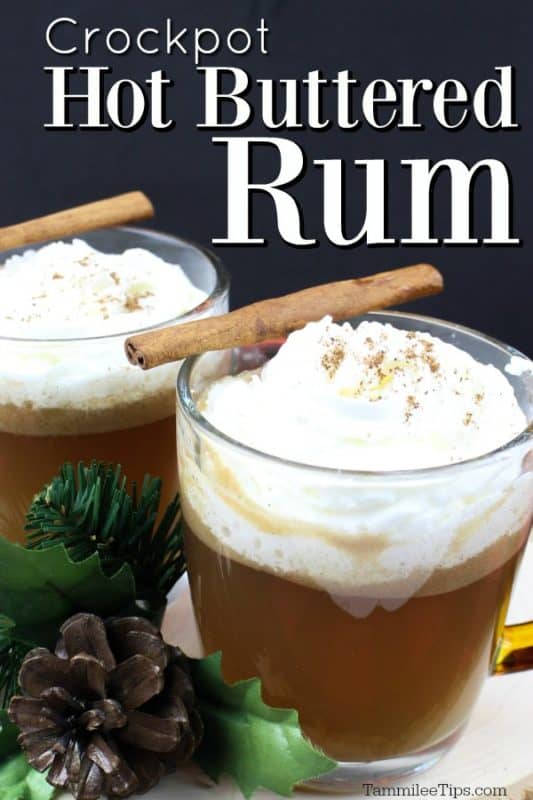 Crockpot Hot Buttered Rum over two mugs garnished with whipped cream and a cinnamon stick