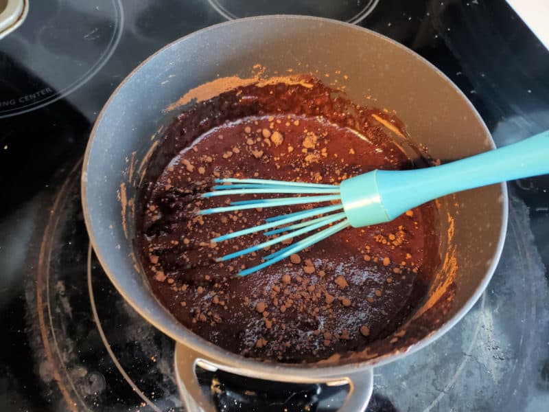 blue whisk in a pan of chocolate being mixed