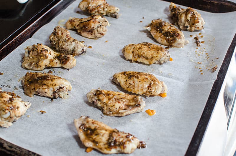 Jerk chicken wings on a parchment lined baking sheet