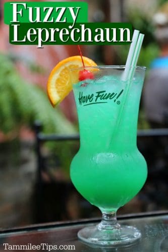 Fuzzy Leprechaun text over a bright green cocktail in a hurricane glass with an orange wheel