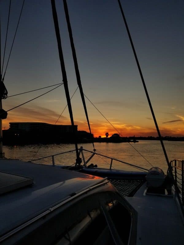 sunset from on a sail boat with ropes in front 