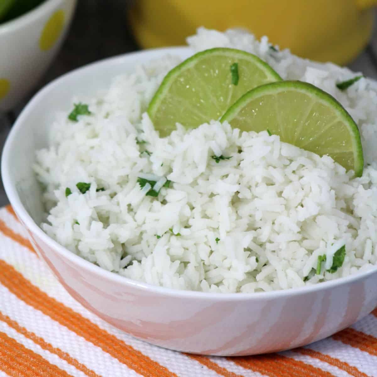 Cilantro Lime Rice in a white bowl with lime wedges.