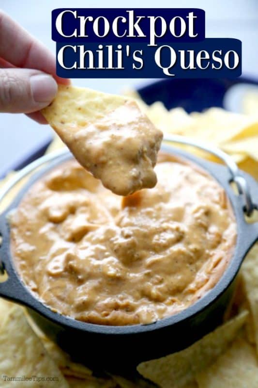 Crockpot chili's queso over a hand holding a chip dipping into chili's queso