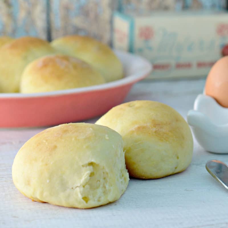 sweet bread rolls next to a bread knife and eggs