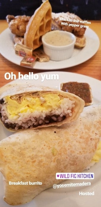 Breakfast burrito on a white plate with chicken and waffles in the background at the Wild Fig Kitchen in Coarsegold, Ca
