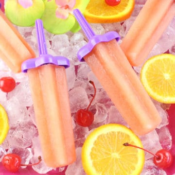 Bahama Mama Popsicles on a bed of ice with orange slices and maraschino cherries
