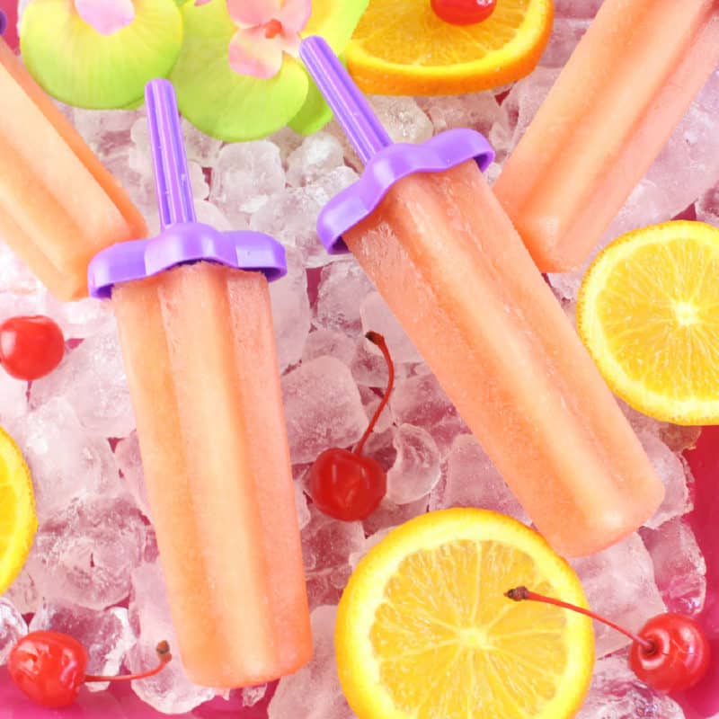 Bahama Mama Popsicles on a bed of ice with orange slices and maraschino cherries