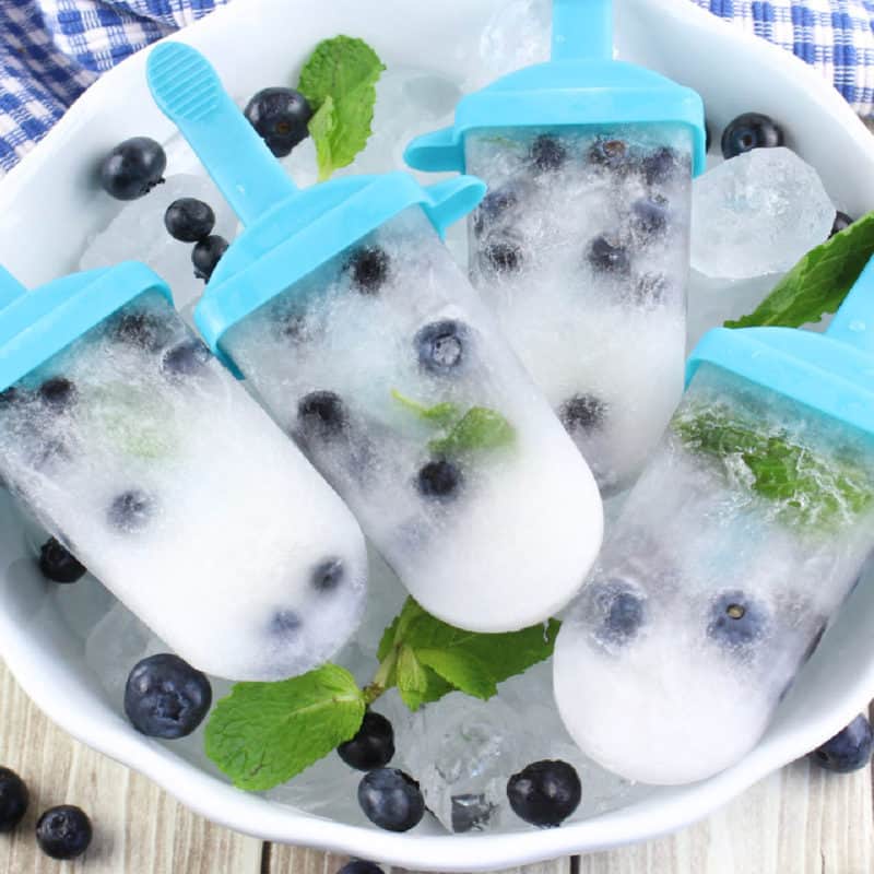 Blueberry Mojito Popsicles in a white bowl with ice