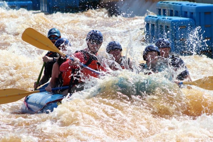 Raft with people holding yellow paddles 