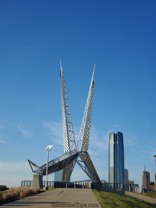 Silver skybridge towers with large sky scraper in the background 