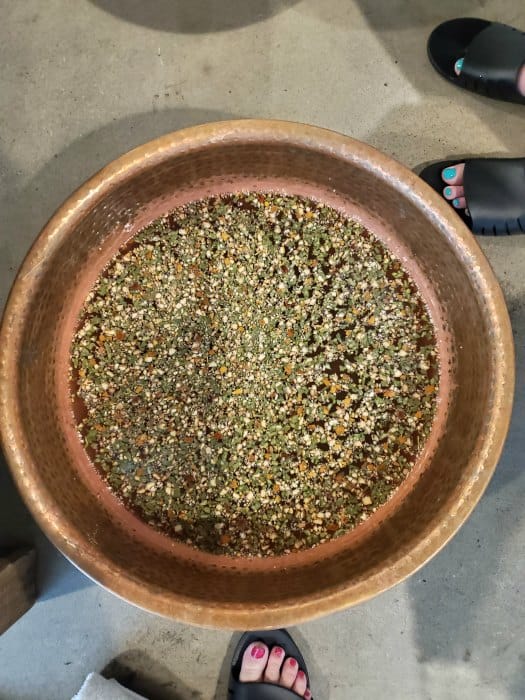 water in a copper bowl with feet standing next to it