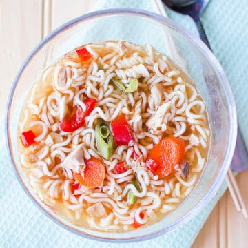 Chicken Ramen Soup in a glass bowl next to a spoon