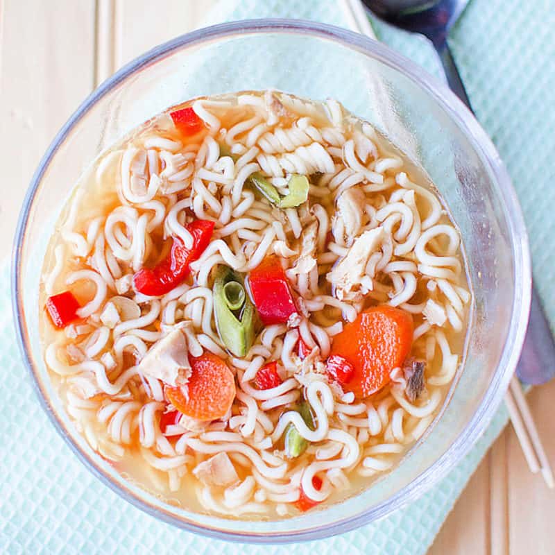 Chicken Ramen Soup in a glass bowl next to a spoon